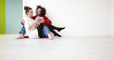Young Couple using digital tablet on the floor photo