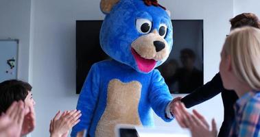 boss dresed as bear having fun with business people in trendy office photo