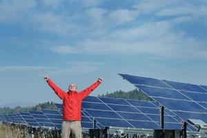 engineer using laptop at solar panels plant field photo