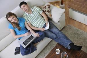 young couple working on laptop at home photo