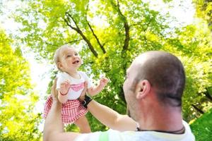 man and baby playing in park photo