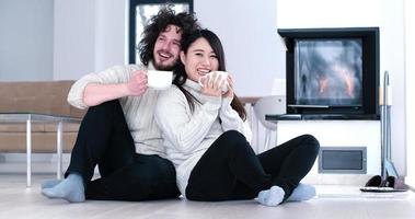 multiethnic romantic couple  in front of fireplace photo