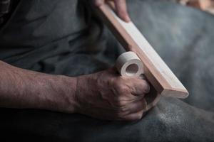 Hands carving cup from wood, working with chisel close up. Wooden workshop. Process of making wooden kitchenware photo