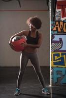 black woman carrying crossfit ball photo