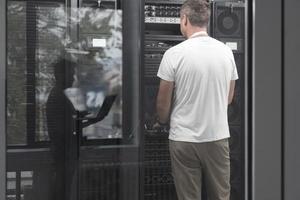 Technicians team updating hardware inspecting system performance in super computer server room or cryptocurrency mining farm. photo