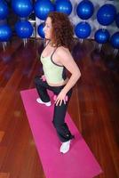 mujer bonita joven haciendo ejercicio en un gimnasio foto