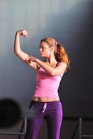 young woman with strong arms rising hands in air photo