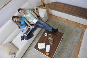 young couple working on laptop at home photo