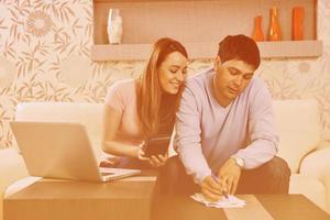 young couple working on laptop at home photo