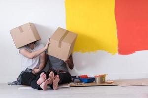 young multiethnic couple playing with cardboard boxes photo