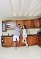 happy young couple have fun in modern kitchen photo