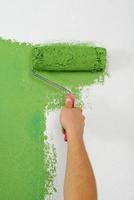 handsome young man paint white wall in color photo