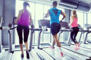 Group of people running on treadmills photo
