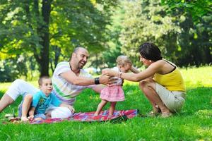 happy young couple with their children have fun at park photo