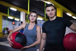 pareja de jóvenes atletas trabajando con pelota médica foto