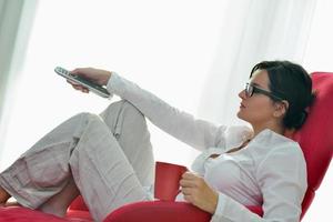 young woman watching tv at home photo