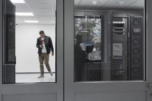 Technicians team updating hardware inspecting system performance in super computer server room or cryptocurrency mining farm. photo