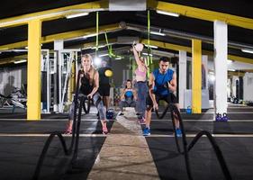 sports couple doing battle ropes cross fitness exercise photo