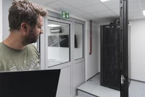 Close up on Data Center Engineer hands Using keyboard on a supercomputer Server Room Specialist Facility with Male System Administrator Working with Data Protection Network for Cyber Security. photo