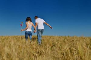 pareja feliz en campo de trigo foto