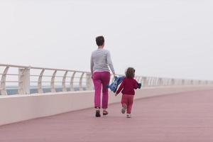 madre y niña linda en el paseo marítimo junto al mar foto