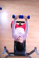 .a young woman weightlifting at gym photo