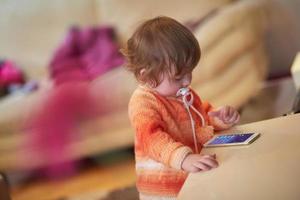 bebe jugando con tablet en casa foto