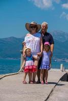 portrait of grandparents and granddaughters standing by the sea photo