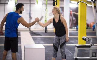 woman working out with personal trainer jumping on fit box photo