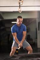 man workout with hammer and tractor tire photo
