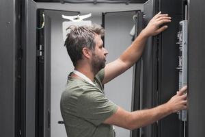 IT engineer working In the server room or data center The technician puts in a rack a new server of corporate business mainframe supercomputer or cryptocurrency mining farm. photo