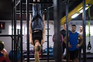 woman working out with personal trainer on gymnastic rings photo