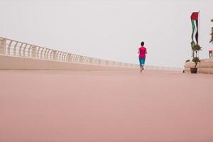 mujer ocupada corriendo en el paseo marítimo foto