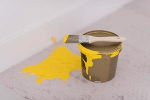 Yellow paint tin can with brush on top photo
