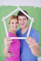 pareja feliz pintando una pared en su nuevo hogar foto