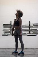 black woman lifting empty bar photo