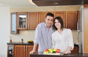 feliz pareja joven divertirse en la cocina moderna foto