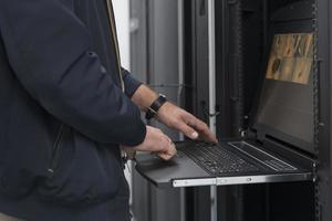Close up on Data Center Engineer hands Using keyboard on a supercomputer Server Room Specialist Facility with Male System Administrator Working with Data Protection Network for Cyber Security. photo