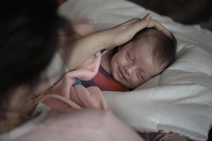 new born baby sleeping and in dreams smillling photo