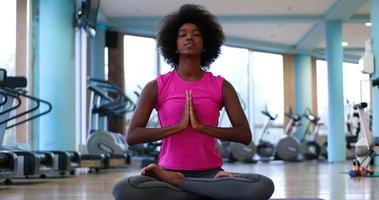 back woman in a gym stretching and warming up photo