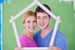 pareja feliz pintando una pared en su nuevo hogar foto