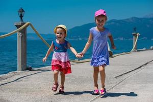 little sisters running on the beach coast photo