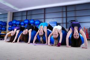 hermosas chicas jóvenes haciendo ejercicio en un gimnasio foto