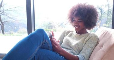 african american woman at home using digital tablet photo