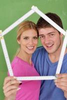 pareja feliz pintando una pared en su nuevo hogar foto