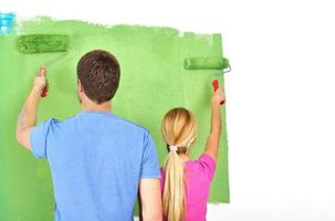 happy couple paint wall at new home photo