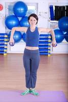 .feliz mujer joven haciendo ejercicio en un gimnasio foto