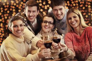 grupo de jóvenes felices beben vino en la fiesta foto