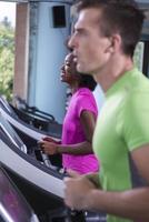 people exercisinng a cardio on treadmill in gym photo