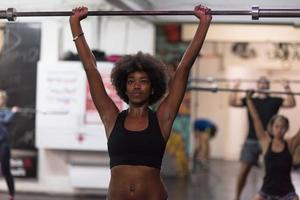 black woman lifting empty bar photo